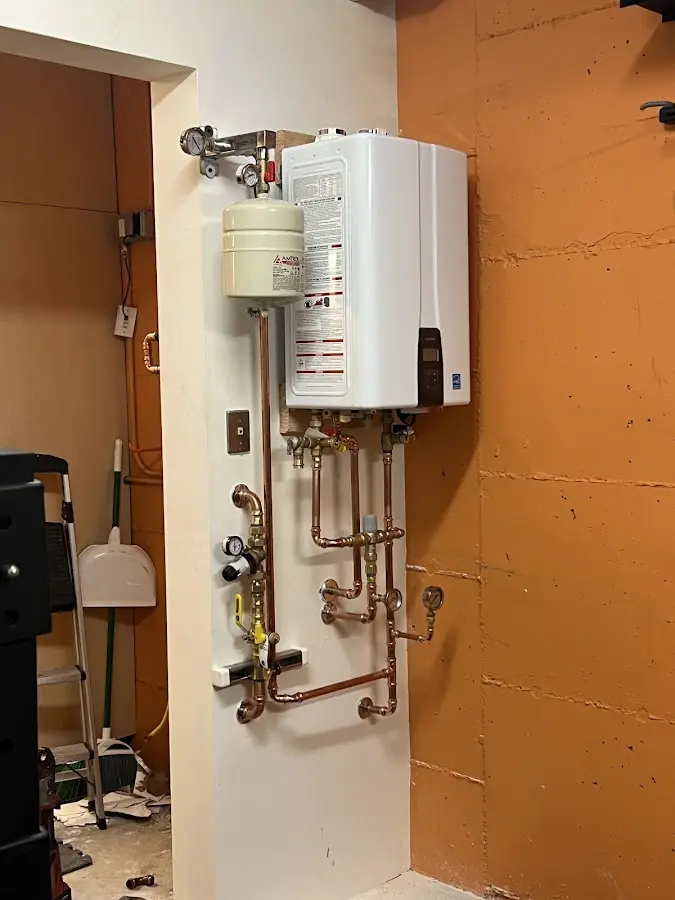 Plumbing technician inspecting water heater connections in Madera